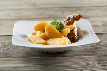 Shot of a delicious meal on a wooden table at the local restaurant fried sliced potatoes and chicken sausage food delicacy gourmet cusine cooking recipe dinner lunch concept.