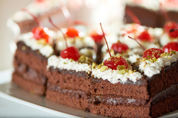 Close up cropped shot of delicious sliced chocolate cake with whipped cream and cherries on top copyspace layout delicacy recipe baking confectionery sweets coffee shop.