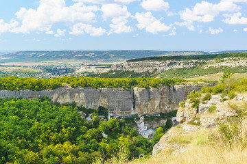 Landscape view on the natural boundary of Mariam-Dere (Canyon of Maria), Holy assumption Orthodox cave monastery and the town of Bakhchisaray on the horizon