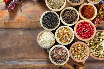 Variety of different asian and middle east spices, colorful assortment, on old wooden table
