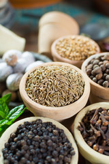 Variety of different spices with focus on ancient famous spice – dried whole cumin seeds with variety of another herbs and spices in Middle East style