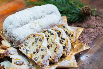Traditional German Christmas raisins and dried fruits cake with sugar powder and Christmas decorations