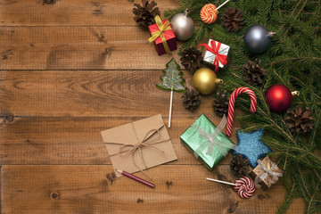 Christmas toys and gifts on wooden background with fir branches and cones