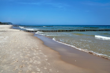Sandy beach and wooden breakwaters on the Baltic coast.