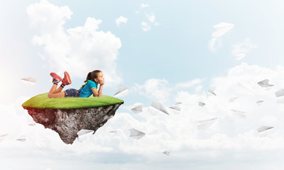 Concept of careless happy childhood with girl dreaming about something