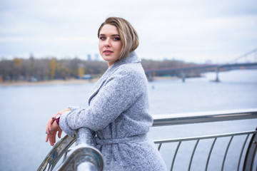 Cute simple woman with blonde hair of size plus size walks through the shopping looks in showcases...