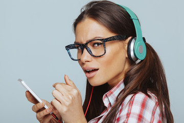 Beautiful geek woman enjoy the music via smartphone