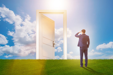 Businessman standing in front of door into future