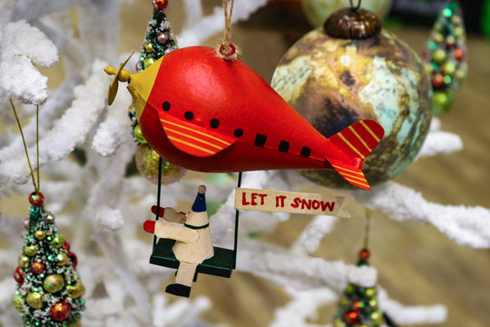 Christmas Robot Riding Red Blimp With Let It Snow Sign On White Fluffy Christmas Tree With Other Ornaments