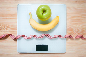 Healthy diet, fitness and weight loss concept, apple, scales, notepad, pencil, measuring tape on the table. View from above.