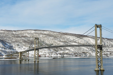 The Tjeldsund suspension road Bridge in winter crossing the Tjeldsundet strait, Troms county, Norway. It is part of a network of bridges that connect islands of Vesteralen and Lofoten to the mainland.
