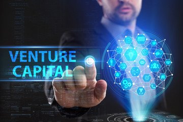 The concept of business, technology, the Internet and the network. A young entrepreneur working on a virtual screen of the future and sees the inscription: Venture capital