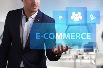 Business, Technology, Internet and network concept. Young businessman working on a virtual screen of the future and sees the inscription: E-commerce