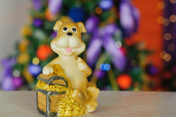 toy dog, the symbol of the new 2018, on the background of Christmas tree bring happiness and money