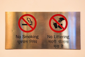 No Smoking and no littering signs on metal plate