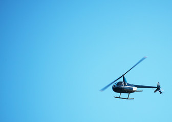 Small private helicopter in the sky. Place for text.