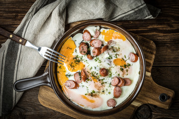 Tasty cooked egg with chopped sausages.