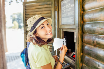 Woman buying tickets to amusement theme park or to the ancient town excursion