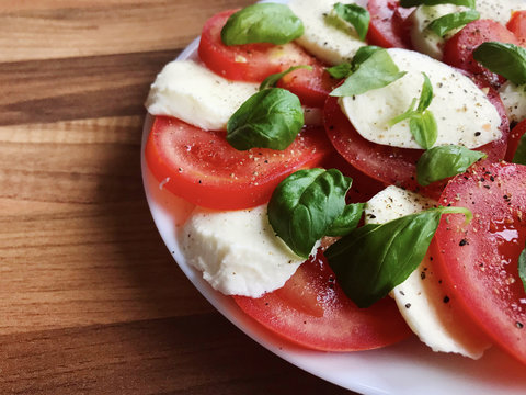 Photo of healthy salad with mozzarella, tomato and basil