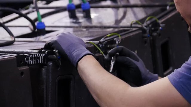 Lighting technicians intstalling professional lighting equipment. Man lighting engineer is working on a device