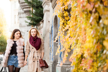 Best friends women in the city holding each other hands, walking and having fun. Friendship and style