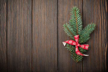 Christmas or New Year background. Fir-tree branches , Christmas tree toys, stars, snowflake and cones on dark brown wooden background. Selective focus. Top view. Copy space.