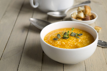 Vegetarian pumpkin soup on a wooden table.