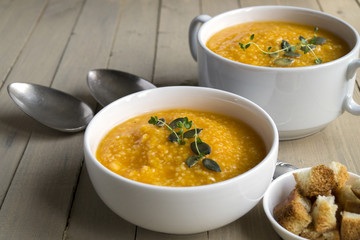 Vegetarian pumpkin soup on a wooden table.