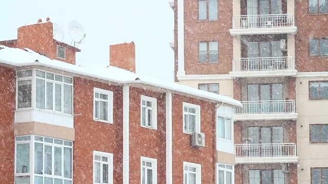 Snow falling in front of the living block of flats. Living flats in winter