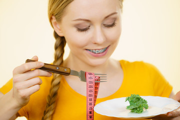 Woman on diet holding plate with lettuce