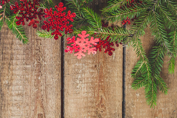 fir christmas tree and garland on a wooden texture (background of the board)
