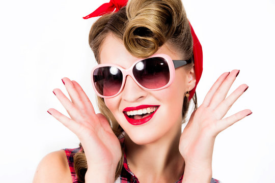 Happy girl in pin-up style wearing sunglasses on white background