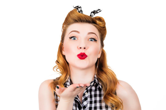 Happy pretty pin up girl sending a kiss over white background