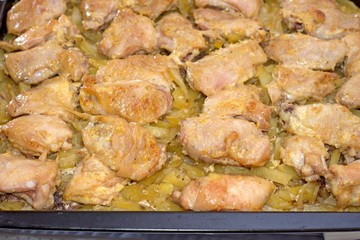 Woman at home fries chicken meat on a frying pan. The meat is not yet fried, raw
