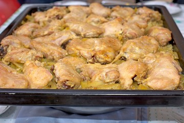 Woman at home fries chicken meat on a frying pan. The meat is not yet fried, raw