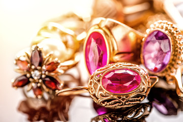 Elegant luxury composition of gold jewelry with ring with red amethyst and ruby gemstone and...
