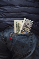 Two bundles of American hundred dollar bills in the back jeans pocket.
