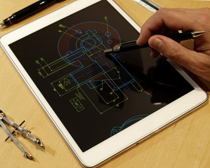 engineer working on mechanical piece design blueprint using a tablet computer