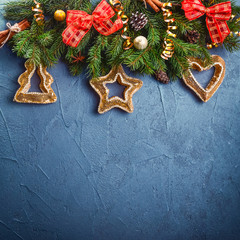 Dark blue christmas background with fir branches and new year decor and toys on a slate or stone backdrop. Top view with copy space. Selective focus