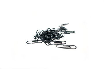 Clip for office accessories. Stationery. Black clips in a chaotic order.