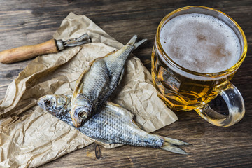 Traditional Russian snacks to beer. Dried roach on paper.
