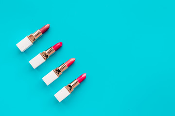 Lipsticks assorted colors on blue background top view copyspace