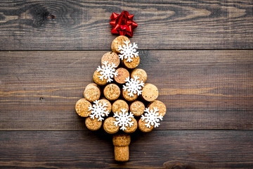 Corks of wine bottles in shape of new year spruce on dark wooden background top view copyspace