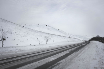 Winter road at the foot of the snow-capped hill