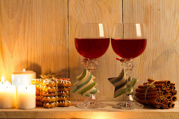Two glasses of wine with Christmas accessories on wooden shelf. New Year and Chrismas concept, background. Sweet home