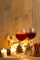 Two glasses of wine with Christmas accessories on wooden shelf. New Year and Chrismas concept, background. Sweet home