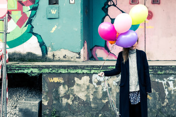 angry young woman with colorful balloons