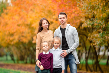 Portrait of happy family of four in autumn day
