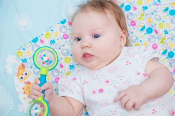 Baby with rattle in hand.