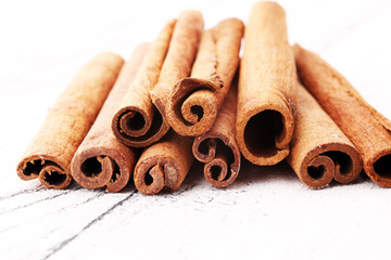 Ground cinnamon, cinnamon sticks, on white background in rustic style